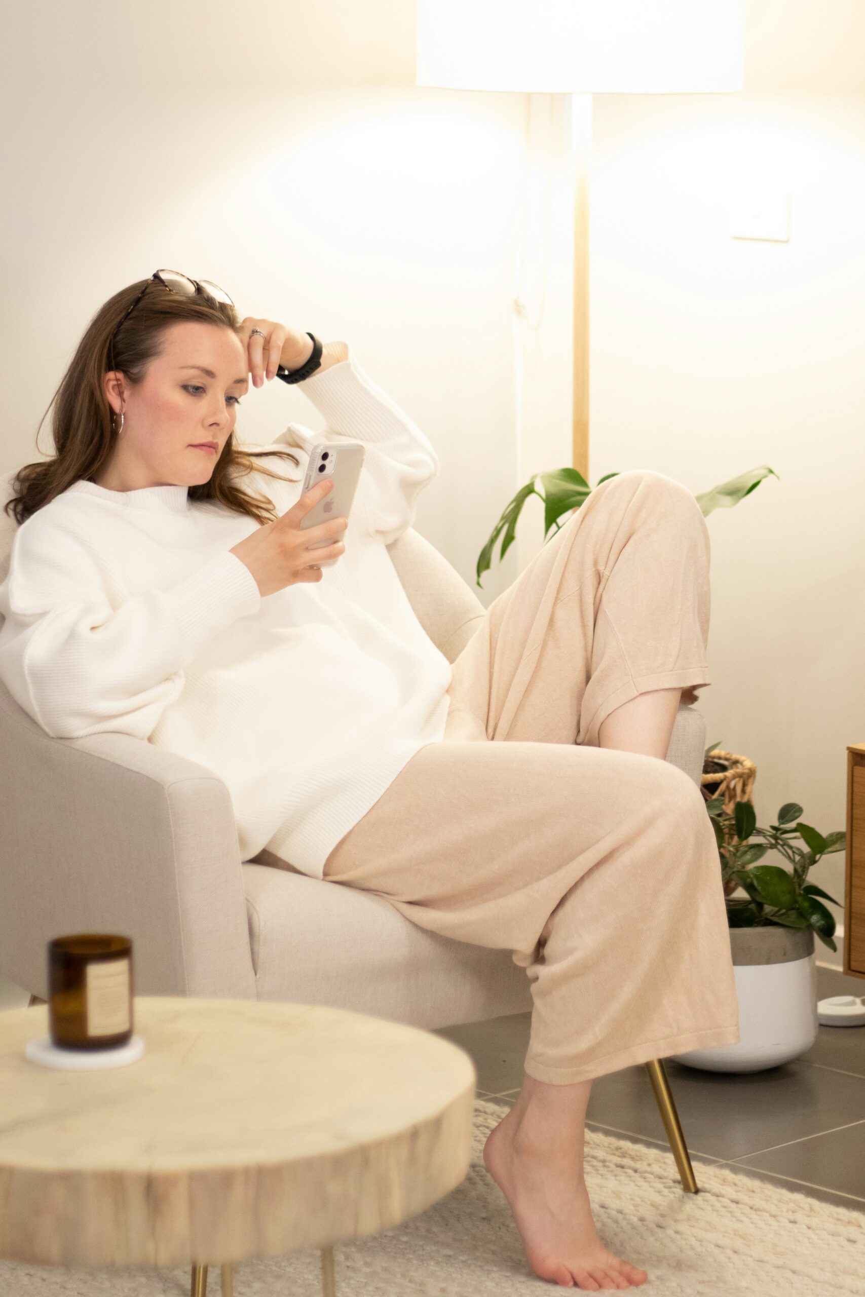 a woman sitting on the sofa looking at her mobile.