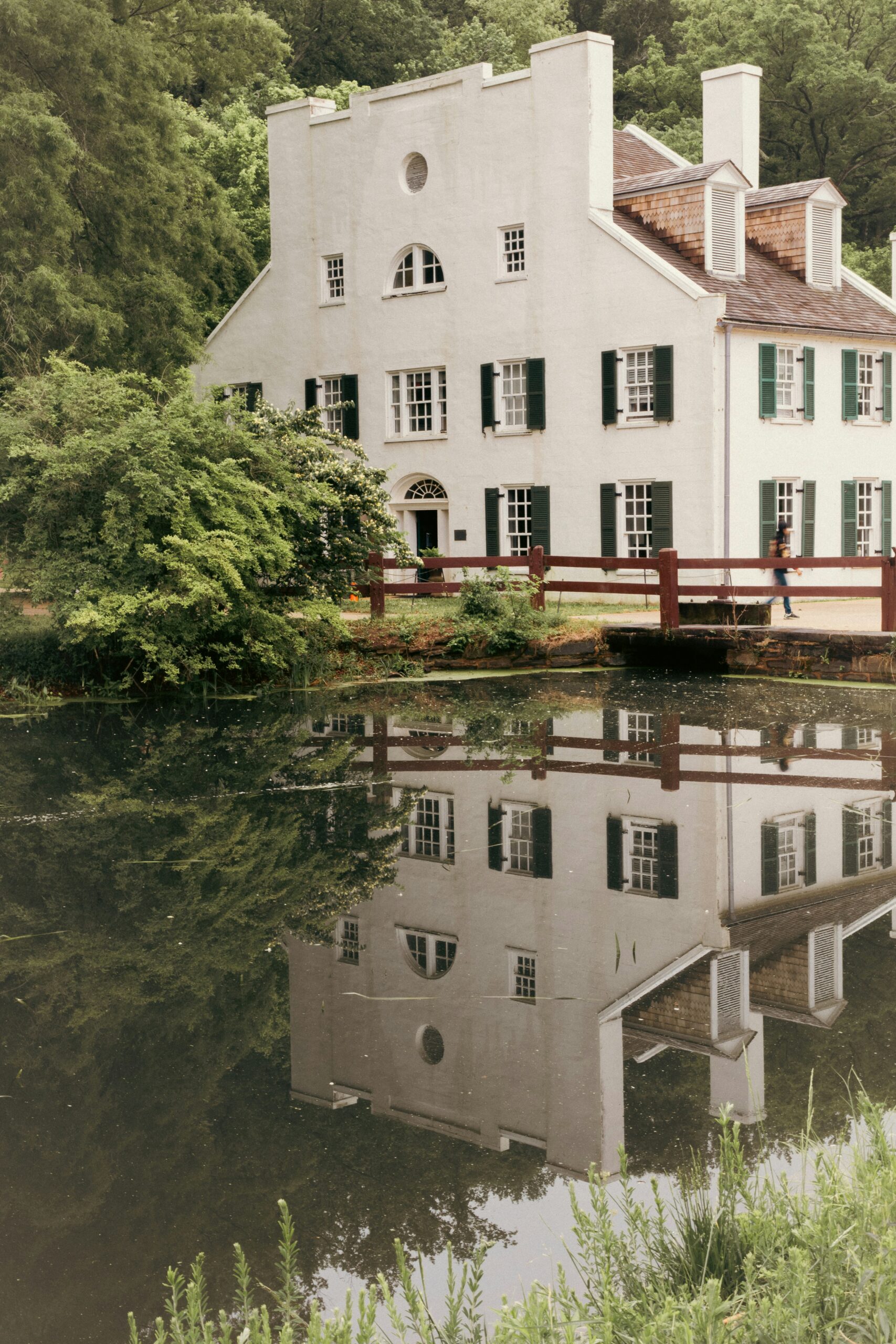 Large white building in Virginia with its shadow reflected in the flowing water.
