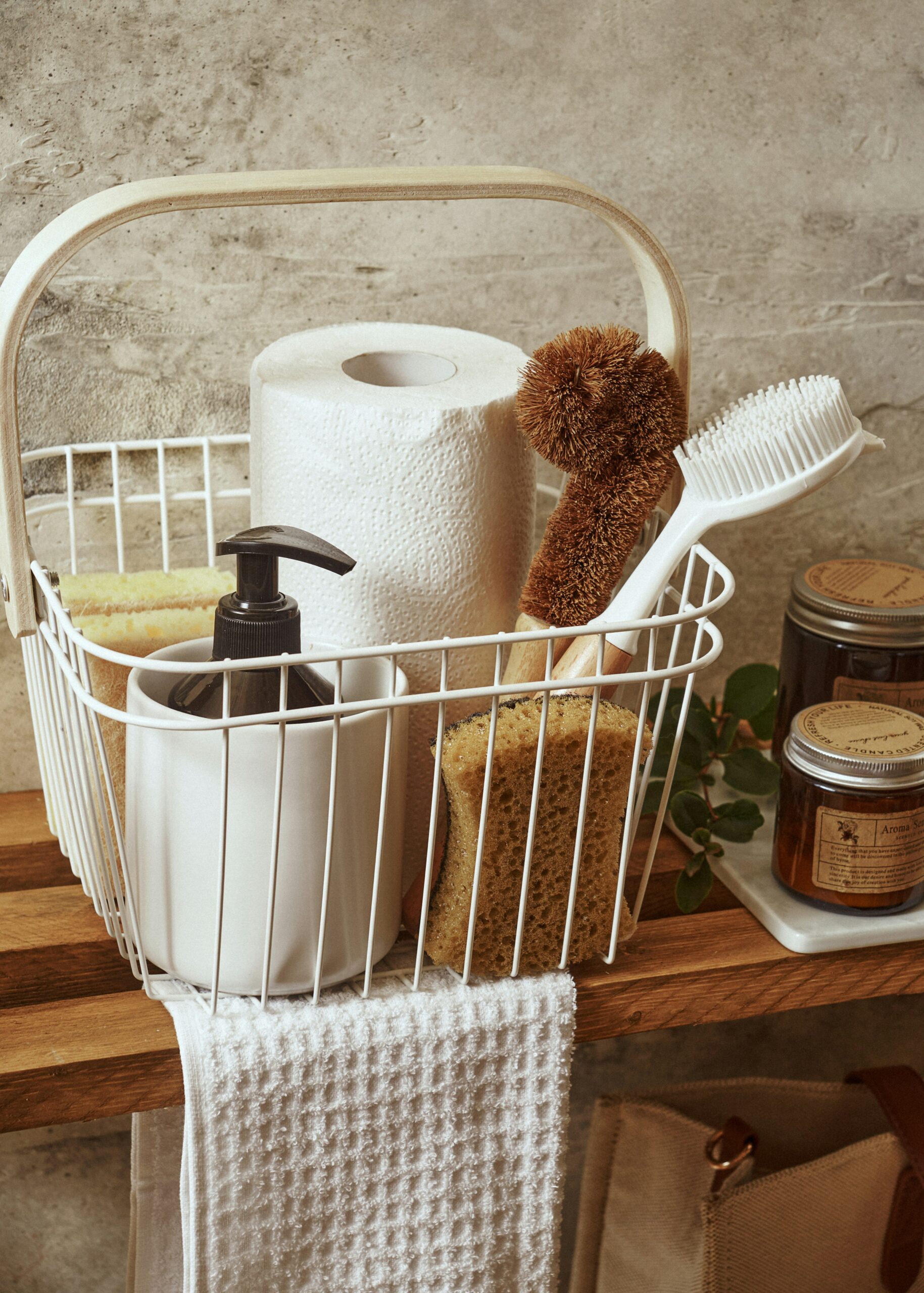 A white basket filled with cleaning supplies.
