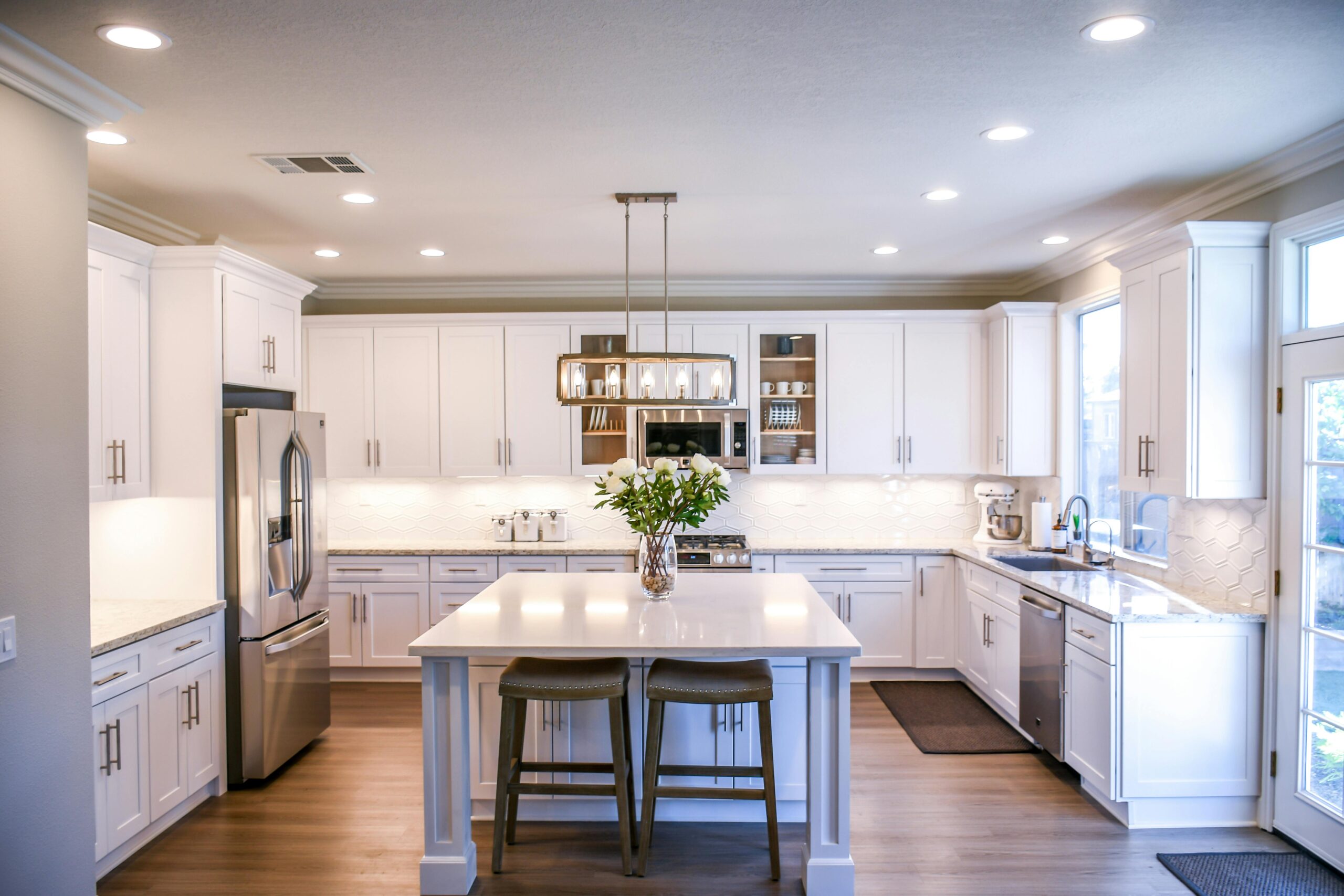 A bright, clean white kitchen with white cabinets.